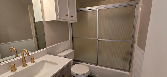 520 Walnut St, Waller, TX 77484 - bathroom with toilet, a wainscoted wall, vanity, and bath / shower combo with glass door