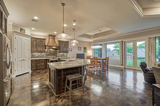 12122 Hawthorne Dr, Montgomery, TX 77356 - kitchen featuring custom exhaust hood, appliances with stainless steel finishes, ornamental molding, a raised ceiling, and tasteful backsplash