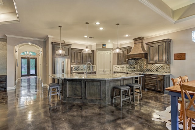 12122 Hawthorne Dr, Montgomery, TX 77356 - kitchen featuring custom exhaust hood, range, a breakfast bar, backsplash, and recessed lighting
