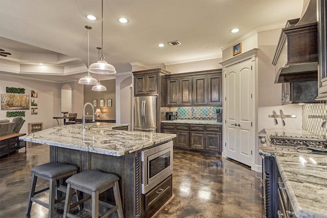 12122 Hawthorne Dr, Montgomery, TX 77356 - kitchen featuring stainless steel appliances, custom range hood, decorative backsplash, crown molding, and dark brown cabinets