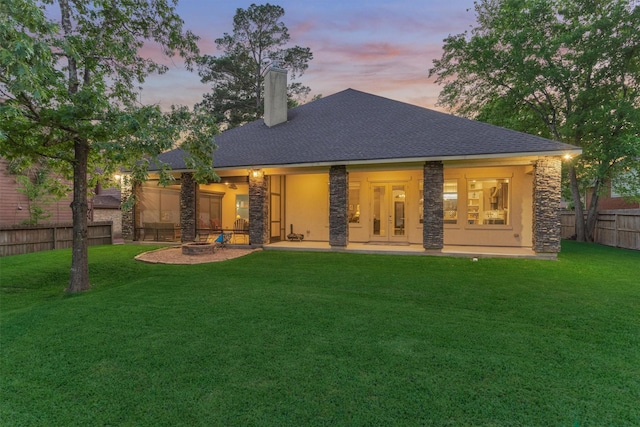 12122 Hawthorne Dr, Montgomery, TX 77356 - rear view of house featuring stone siding, a chimney, a fenced backyard, an outdoor fire pit, and a patio