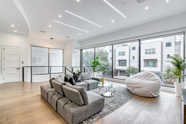 living room with baseboard heating, recessed lighting, visible vents, and light wood-type flooring
