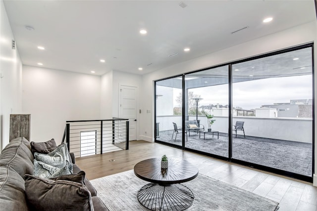 living area with recessed lighting and light wood-style floors