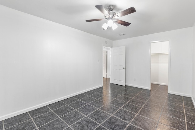 1035 Forestburg Dr, Houston, TX 77038 - unfurnished bedroom with a spacious closet, baseboards, ceiling fan, a closet, and dark tile patterned floors