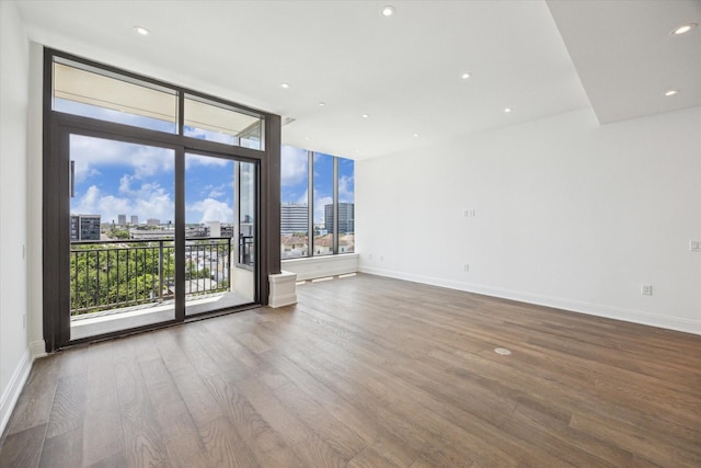 2323 W Main St Unit 603, Houston, TX 77098 - unfurnished room with a skyline view, wood finished floors, baseboards, recessed lighting, and floor to ceiling windows