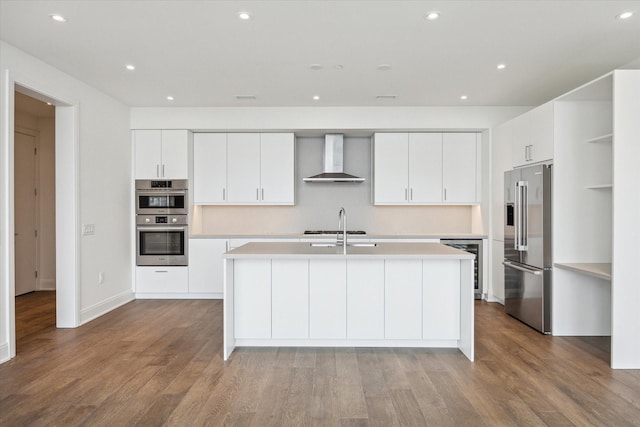 2323 W Main St Unit 603, Houston, TX 77098 - kitchen with appliances with stainless steel finishes, wall chimney range hood, beverage cooler, light countertops, and recessed lighting