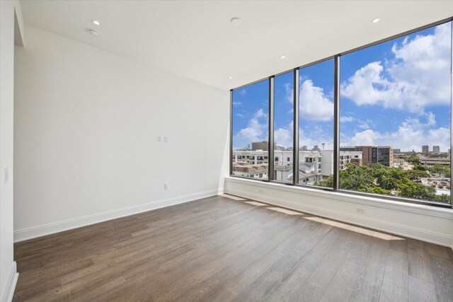 2323 W Main St Unit 603, Houston, TX 77098 - unfurnished room featuring wood finished floors, baseboards, and a view of city
