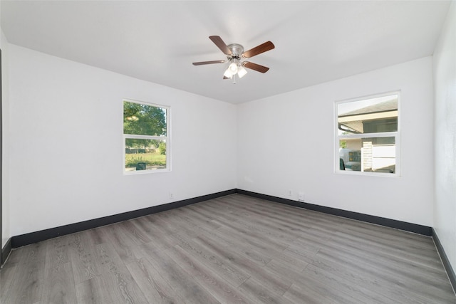 unfurnished room featuring baseboards, a ceiling fan, and wood finished floors