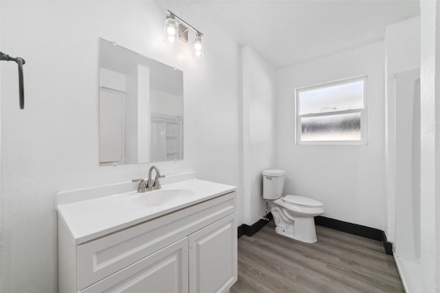 bathroom featuring toilet, wood finished floors, and vanity