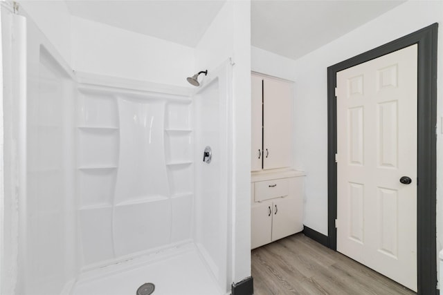 bathroom with a stall shower and wood finished floors
