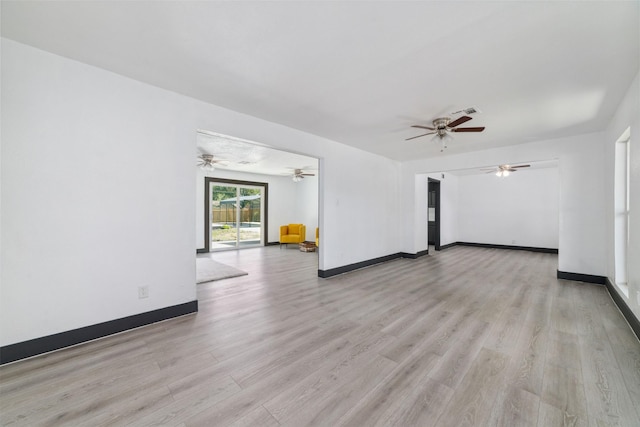 unfurnished living room with visible vents, light wood-style flooring, a ceiling fan, and baseboards