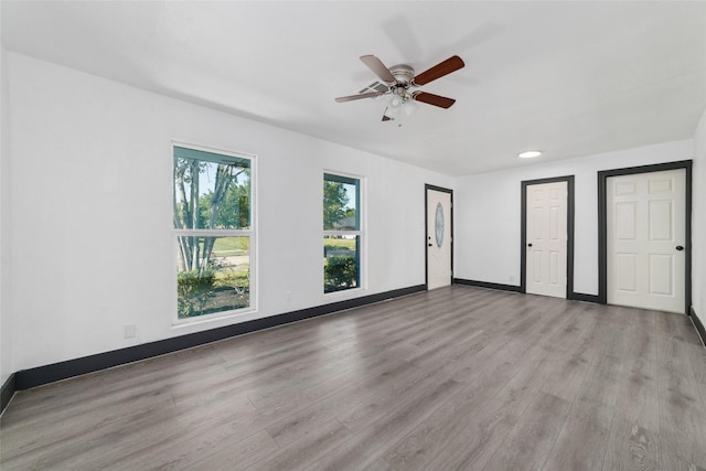 interior space featuring baseboards, a ceiling fan, and wood finished floors