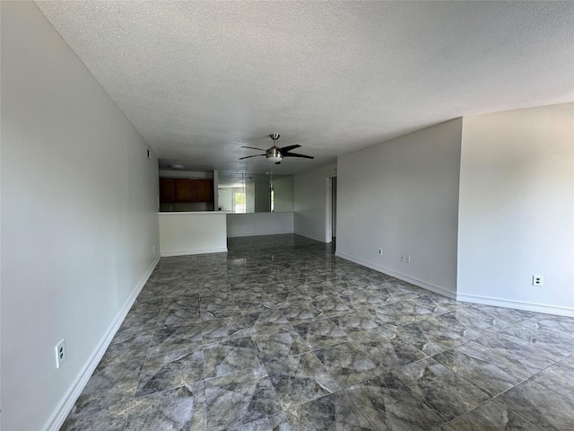 unfurnished living room with a textured ceiling, ceiling fan, and baseboards