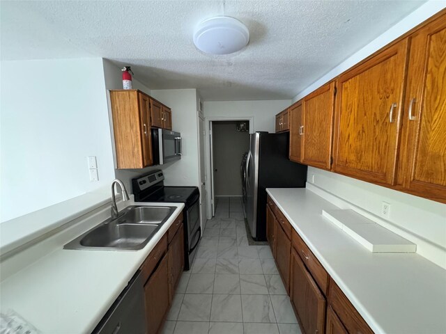 kitchen featuring a sink, brown cabinets, marble finish floor, and stainless steel appliances