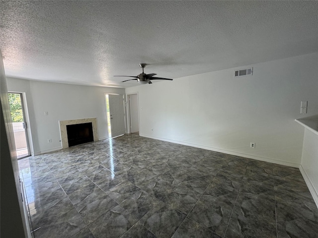unfurnished living room with visible vents, a ceiling fan, a fireplace, and a textured ceiling