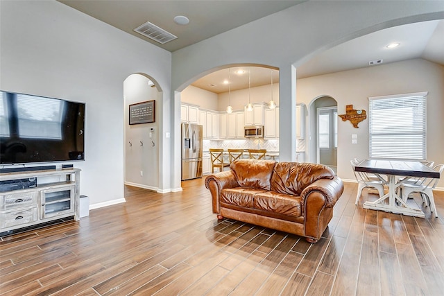 29114 Autumn Brook Dr, Fulshear, TX 77441 - living area with visible vents, baseboards, arched walkways, and wood finished floors