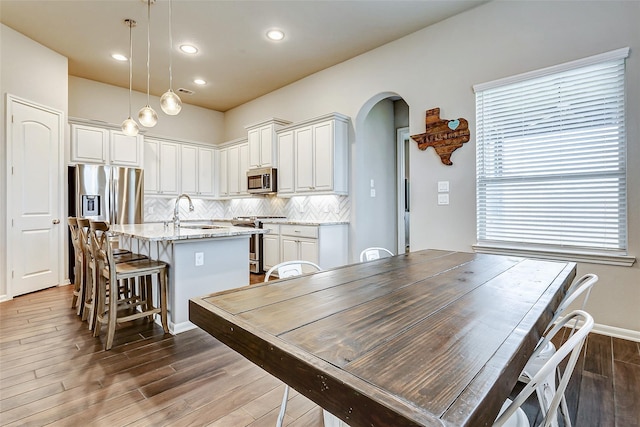 29114 Autumn Brook Dr, Fulshear, TX 77441 - dining room with arched walkways, dark wood-style flooring, baseboards, and recessed lighting