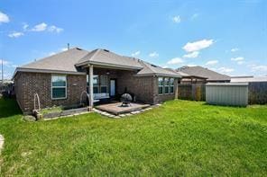 rear view of property featuring fence, a patio, and a lawn