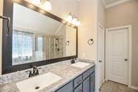 bathroom with double vanity, a sink, and lofted ceiling