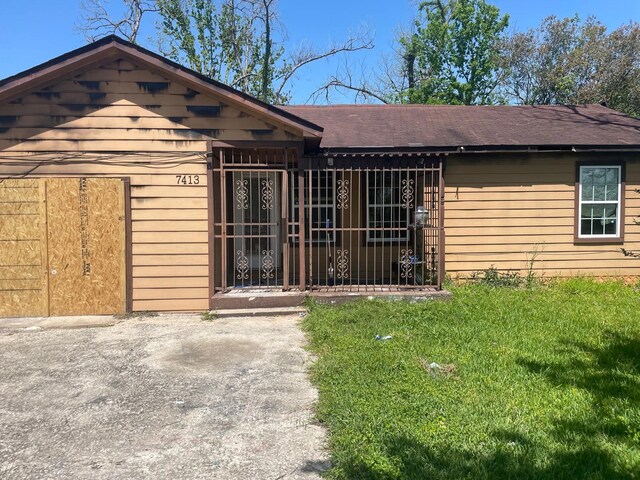 7413 W Knoll St, Houston, TX 77028 - view of front of home with roof with shingles and a front lawn
