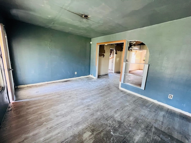 7413 W Knoll St, Houston, TX 77028 - unfurnished bedroom with baseboards, wood finished floors, arched walkways, and a closet