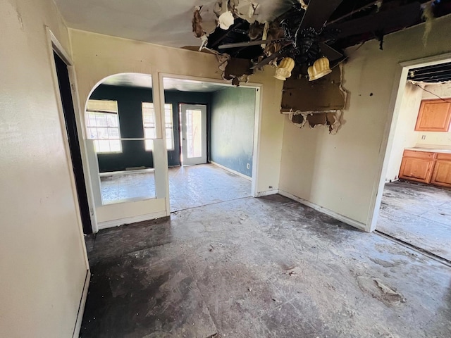 7413 W Knoll St, Houston, TX 77028 - empty room with arched walkways and unfinished concrete flooring