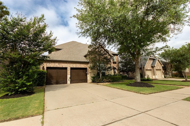 french provincial home with a garage, roof with shingles, stone siding, brick siding, and driveway