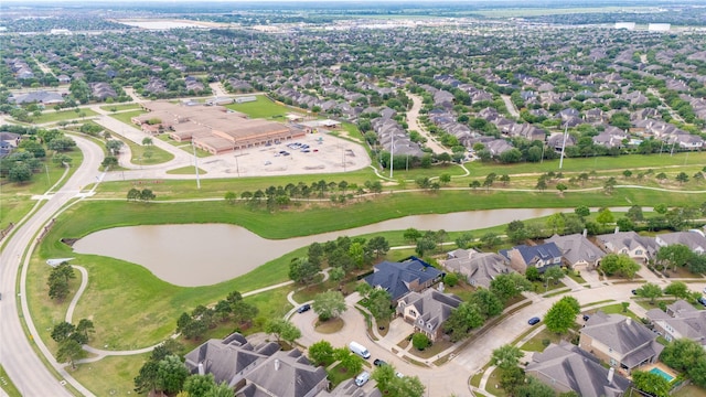 drone / aerial view with golf course view, a residential view, and a water view