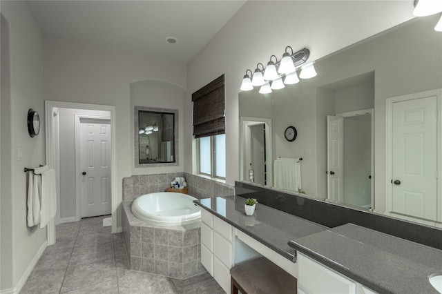 bathroom with tile patterned floors, vanity, a bath, and baseboards