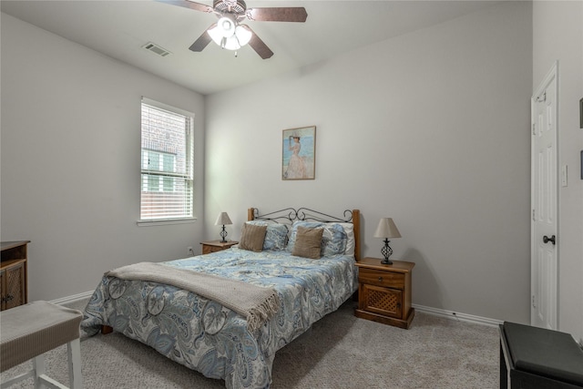carpeted bedroom with baseboards, a ceiling fan, and visible vents