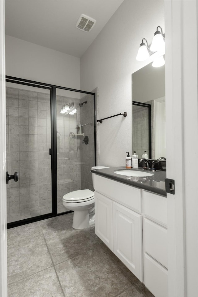 bathroom with vanity, visible vents, toilet, a stall shower, and tile patterned floors