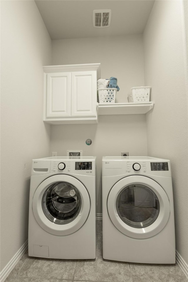 laundry room with cabinet space, visible vents, baseboards, and separate washer and dryer
