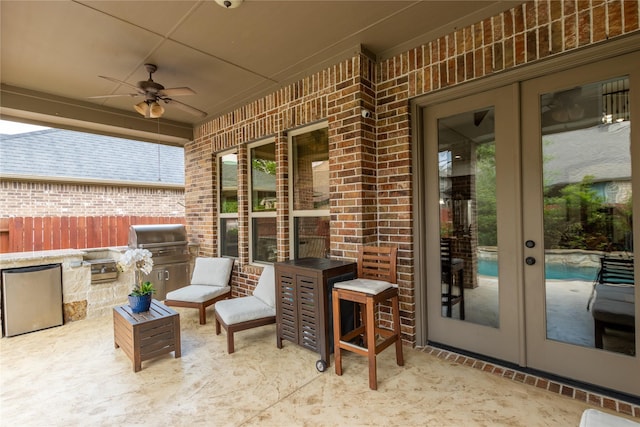 view of patio featuring french doors, exterior kitchen, grilling area, and a ceiling fan