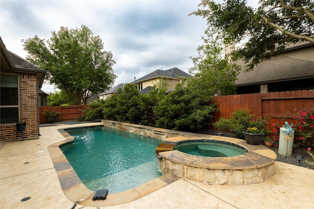 view of pool featuring a fenced backyard, a pool with connected hot tub, and a patio area