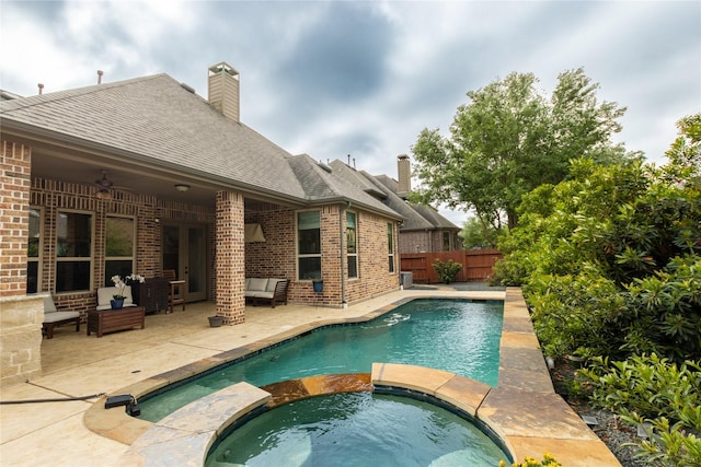 view of pool with a pool with connected hot tub, fence, a patio, and a ceiling fan