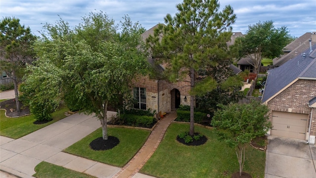 view of front of house with a front yard, driveway, and stone siding