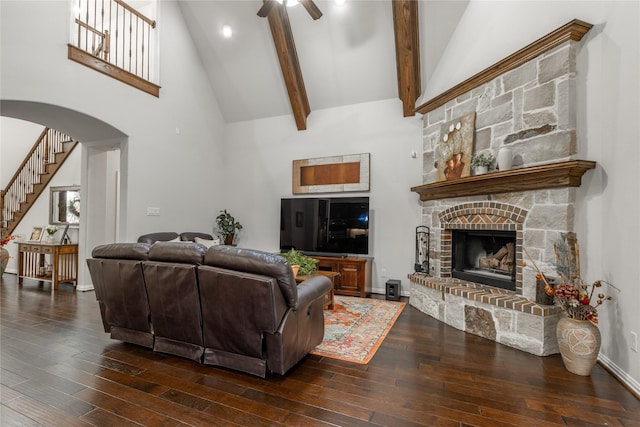 living room featuring a fireplace, ceiling fan, high vaulted ceiling, arched walkways, and hardwood / wood-style flooring