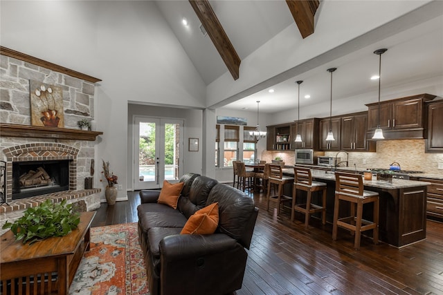living area with high vaulted ceiling, beamed ceiling, dark wood-type flooring, a fireplace with raised hearth, and recessed lighting