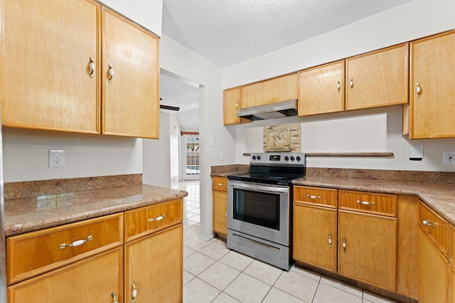kitchen with light tile patterned floors, range hood, electric range, and a textured ceiling