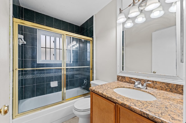 bathroom with combined bath / shower with glass door, toilet, and vanity