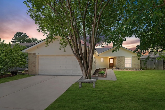 obstructed view of property featuring brick siding, fence, a garage, concrete driveway, and a lawn