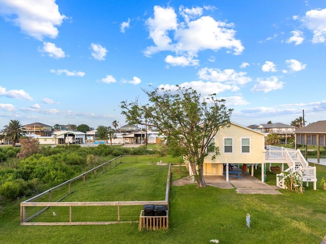 rear view of house with a residential view, a carport, fence, a patio area, and a yard