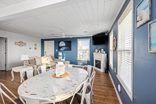dining space with wood finished floors, a ceiling fan, baseboards, wood ceiling, and a glass covered fireplace