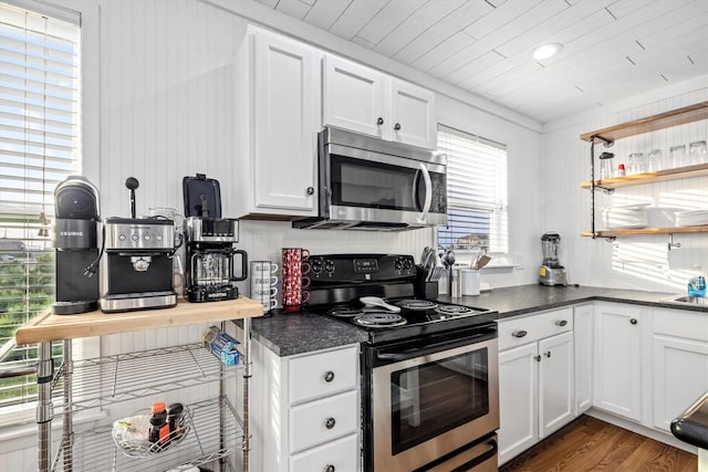 kitchen with dark countertops, appliances with stainless steel finishes, and white cabinetry
