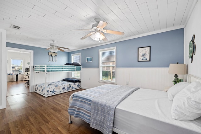 bedroom with wood finished floors, wainscoting, ceiling fan, wooden ceiling, and visible vents