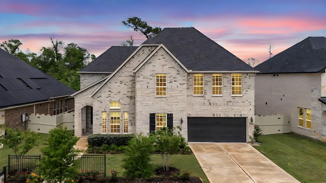 17583 Harpers Way, Conroe, TX 77385 - french country home featuring a front yard, a shingled roof, driveway, an attached garage, and fence