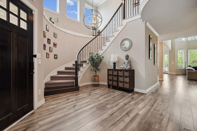 17583 Harpers Way, Conroe, TX 77385 - entrance foyer featuring wood finished floors, a chandelier, baseboards, stairway, and a towering ceiling