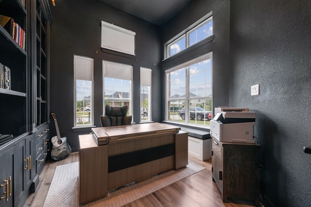 17583 Harpers Way, Conroe, TX 77385 - office area featuring a towering ceiling, light wood-style floors, and a textured wall