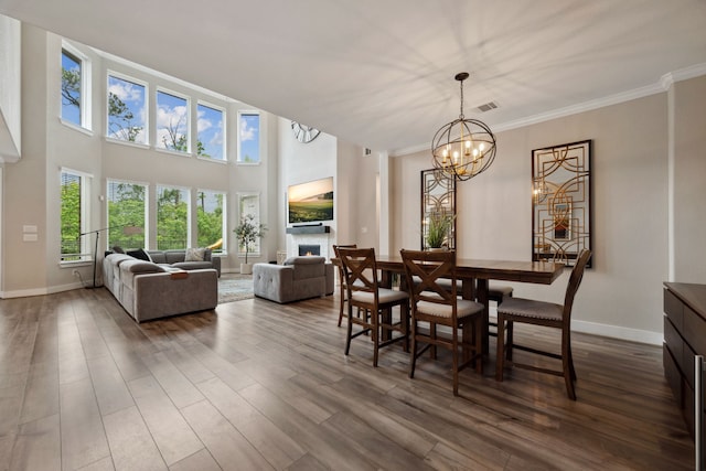 17583 Harpers Way, Conroe, TX 77385 - dining space featuring a chandelier, dark wood-style flooring, baseboards, visible vents, and crown molding