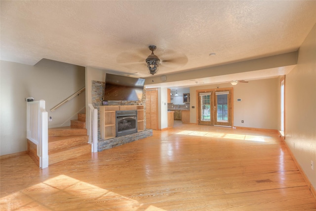 25 S Magnolia Ln, Shepherd, TX 77371 - unfurnished living room featuring light wood-style flooring, a textured ceiling, and a ceiling fan